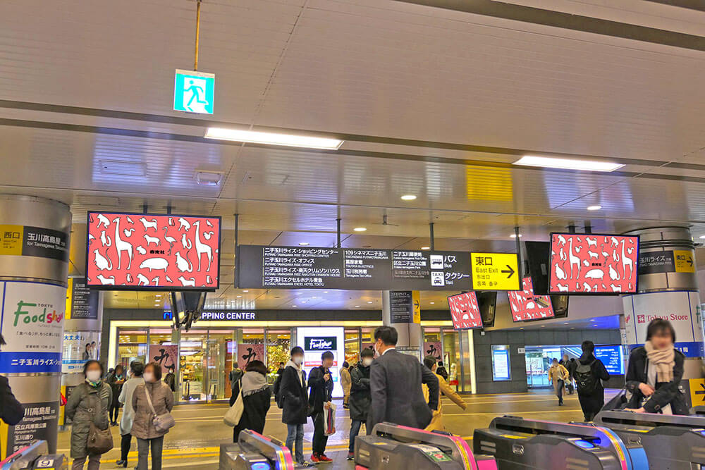 東急二子玉川駅の改札外コンコースの天井から吊り下げられている、ヨコ型のデジタルサイネージ媒体
