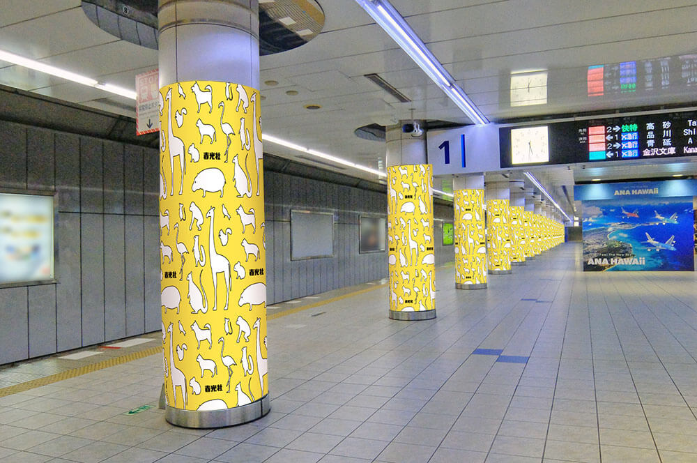 京急羽田空港第1・第2ターミナル駅ホーム・改札内コンコース、多くの乗客が行き交う導線上に掲出される、大型プリント出力シートで巻いた柱全周・全面を広告として使用できる、ユニークな媒体